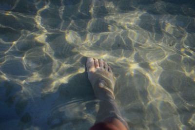 Low section of woman standing in sea