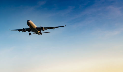 Low angle view of airplane flying against sky