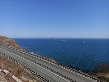 High angle view of road by sea against clear sky