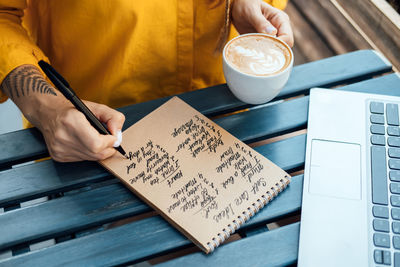 Young woman writing in notebook self-care ideas list for the mind, soul, body