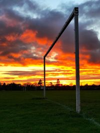 Scenic view of dramatic sky over field during sunset