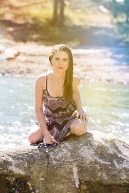 YOUNG WOMAN STANDING ON ROCKS