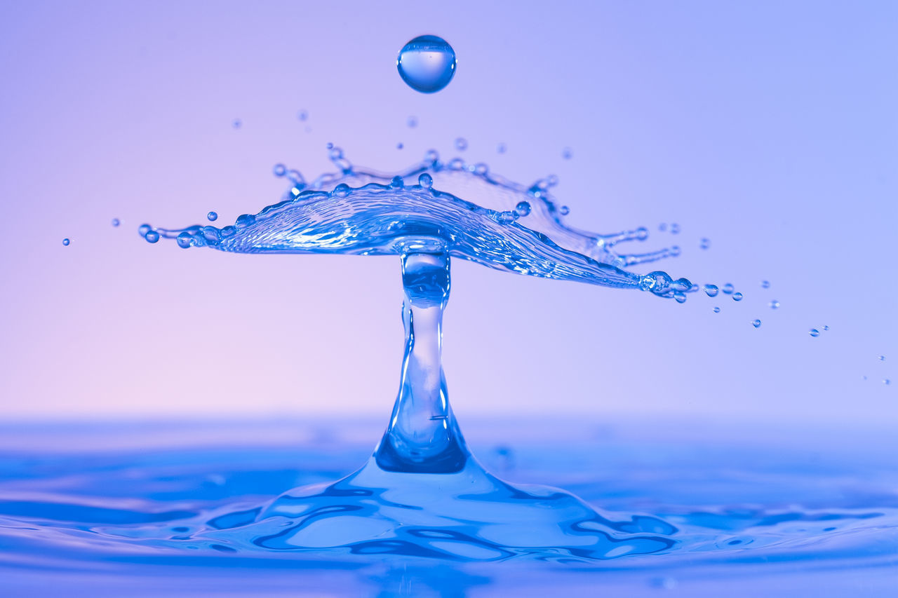 CLOSE-UP OF DROP SPLASHING ON WATER