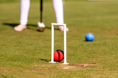 A young woman is playing croquet on a lawn