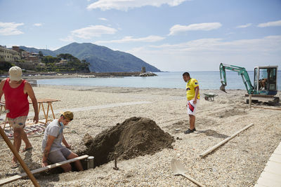 People on beach against sky