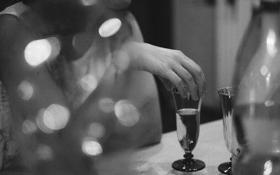 Midsection of man drinking glass on table