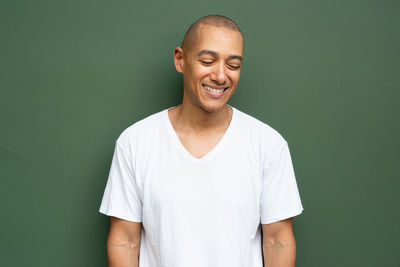 Portrait of young man standing against gray background