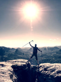 Successful man screaming happiness on mountain peak with raised arms. achieving of personal target