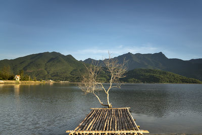 Scenic view of lake by mountains against sky