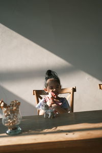 Portrait of cute boy holding umbrella on table