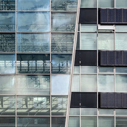 Low angle view of glass building against sky