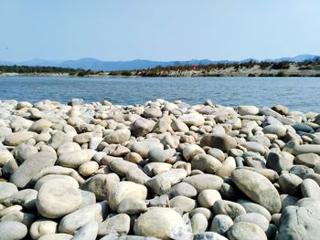 Stones on beach against clear sky