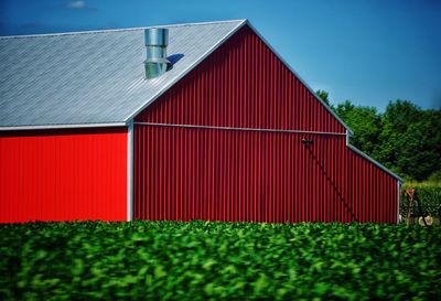 Red barn in farm against sky