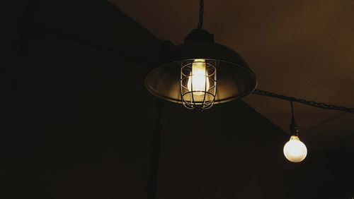 Low angle view of light bulb hanging from ceiling