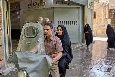 Group of people standing on street in rain