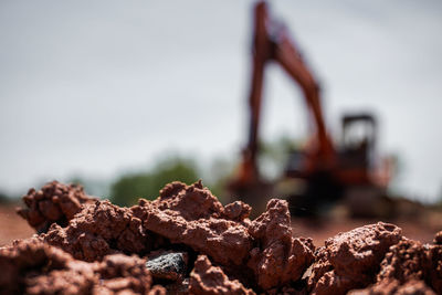 Close-up of rusty metal on rock against sky