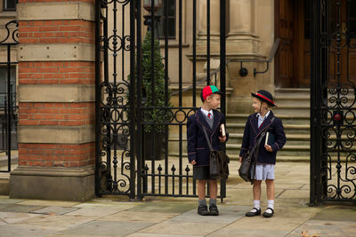 Boy and girl standing by school gate
