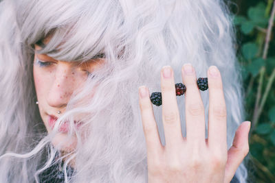 Close-up of female model holding blackberries