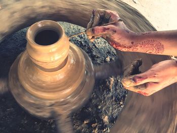 Cropped hands of woman molding pot at workshop