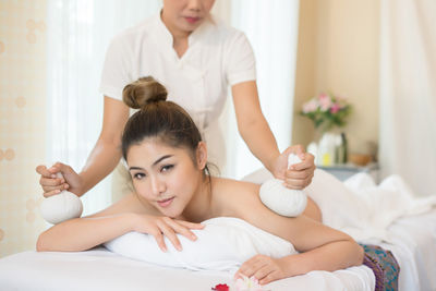 Masseur massaging young woman on table in spa