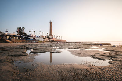 Scenic view of sea and buildings against clear sky