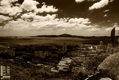 View of cityscape against cloudy sky