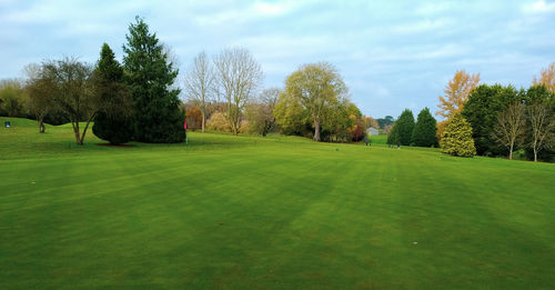 Scenic view of golf course against sky