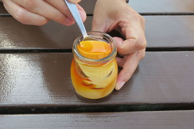 Midsection of person holding dessert on table