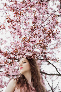 Portrait of woman with pink cherry blossoms in spring