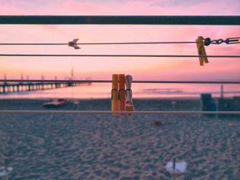 Close-up of water hanging on cable against sky