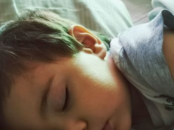 Close-up of baby sleeping on bed