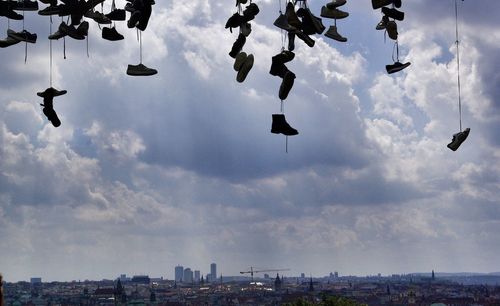 Low angle view of birds flying against cloudy sky