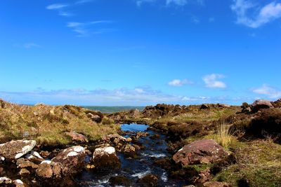 Scenic view of rocks against blue sky