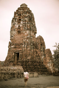 Rear view of woman standing against temple