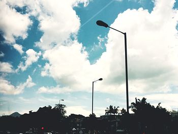 Low angle view of street light against cloudy sky