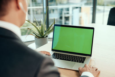 Midsection of businessman using laptop
