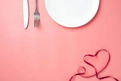 Directly above shot of heart shape on pink table