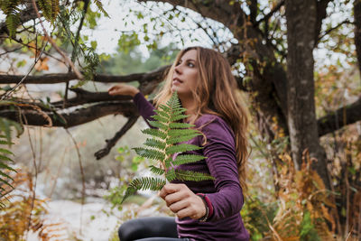 Beautiful young woman against plants