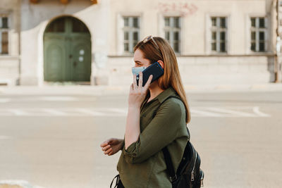 Woman photographing with mobile phone in city