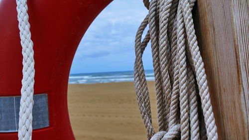 Close-up of rope tied on wooden post at beach