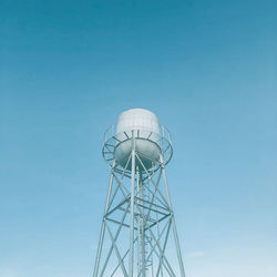 Low angle view of water tower against clear blue sky