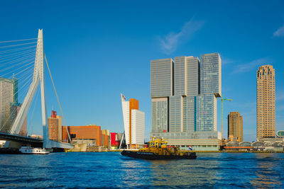 Rotterdam cityscape and erasmus bridge over nieuwe maas on sunset. rotterdam, netherlands