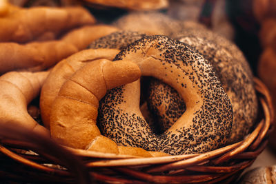 Fresh baked bread buns with poppy seeds in a wicker basket. bakery shop counter