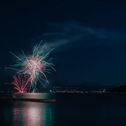 Firework display by sea at night