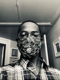 Low angle portrait of man wearing mask at home