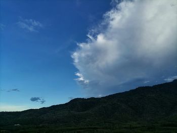 Low angle view of mountains against blue sky