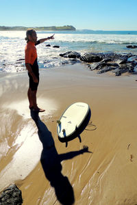 Boy standing on beach against sky