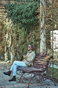 Woman sitting on bench in park