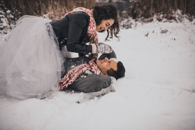 Rear view of woman sitting on snow