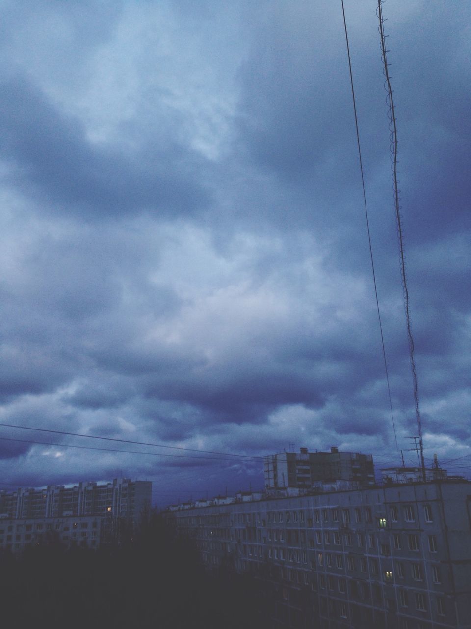 building exterior, architecture, built structure, sky, cloud - sky, cloudy, city, weather, residential building, cloud, low angle view, overcast, building, residential structure, dusk, storm cloud, outdoors, no people, house, power line